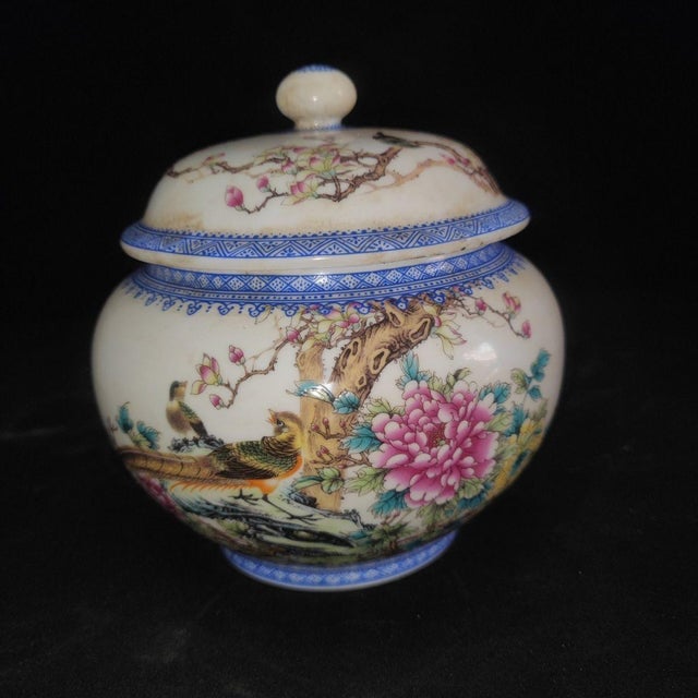 A lovely pair of Chinese Famille Rose porcelain covered jars. The white ground is finely hand-painted with vibrant birds...