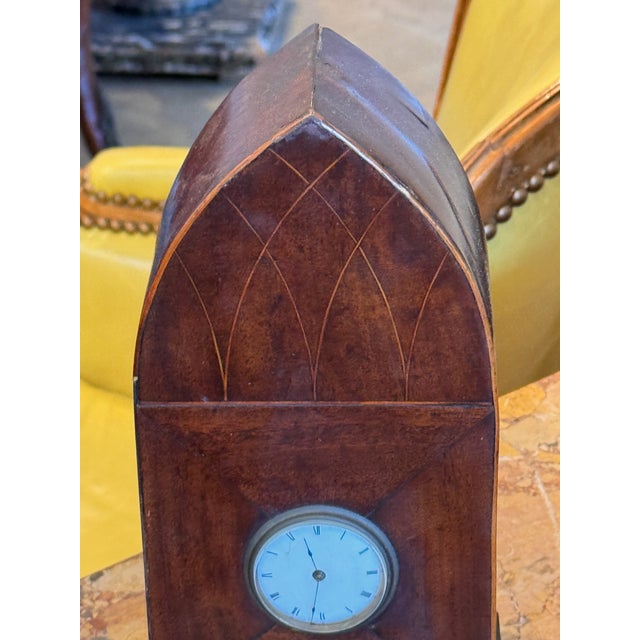 Gothic mantel clock with a lancet-arched case, the front inlaid with a pointed arch tracery design above and radiating...