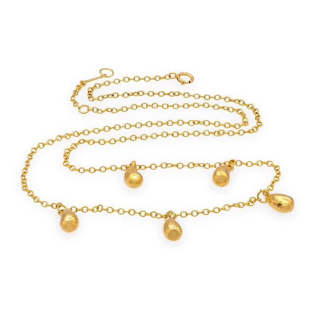 A vintage classic Tiffany & Co. Elsa Peretti necklace crafted in solid 18K yellow gold, featuring five polished teardrop...