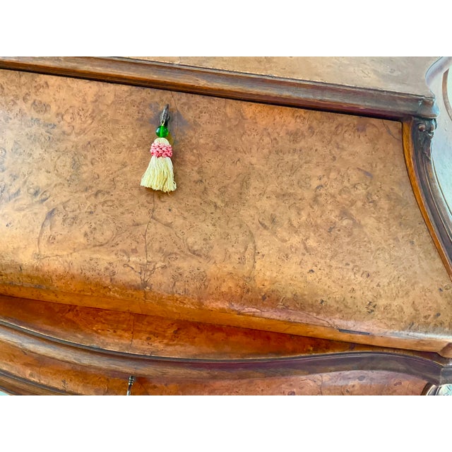 An elegant French Louis XV style fall-front secretary desk, beautifully crafted in richly figured burl walnut with...