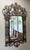 This impressive La Barge wall mirror features an elaborate wrought-iron frame with sweeping scrollwork, floral motifs, and...