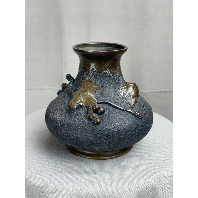 A finely cast Japanese bronze vase, likely late Meiji period (circa 1890–1910), featuring a richly textured body and...