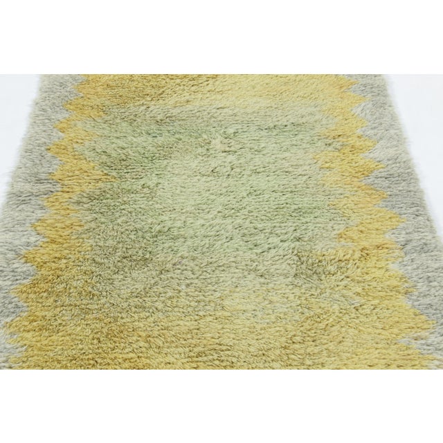 Hand-knotted in lush, high-pile wool in Sweden circa 1960-1970, this 4x6 vintage Swedish Rya rug is a bold new addition to...