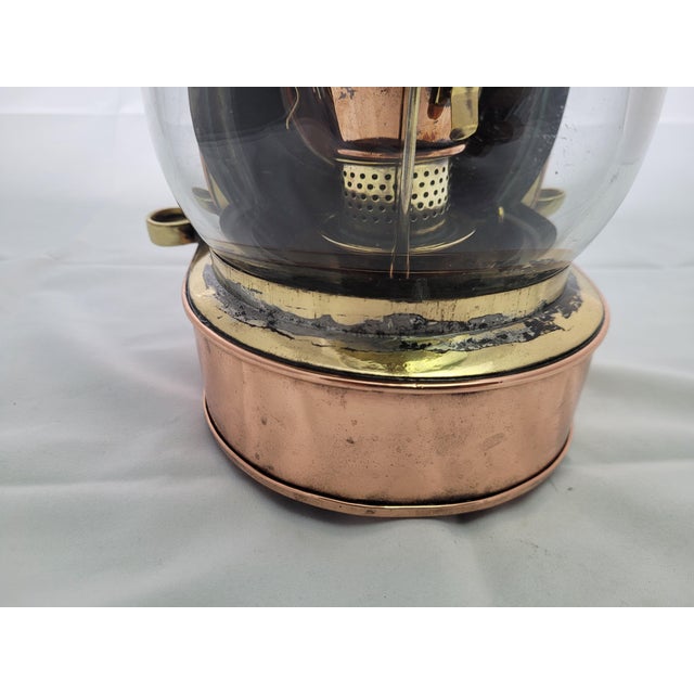 Antique highly polished copper and brass ships masthead lantern. There is a clear globe shaped lens, hinged top, the...