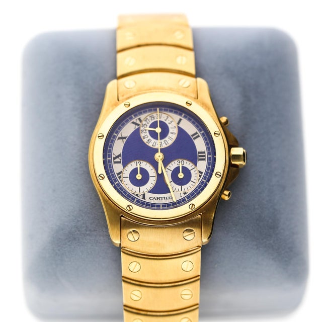 Vintage Cartier Ronde Santos 18K yellow gold quartz chronograph watch featuring a striking blue dial with white subdials,...