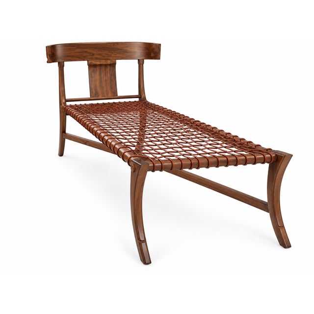 Sophisticated modern chaise lounge in the manner of Robsjohn Gibbings Klismos. The chaise has a walnut finish, with...