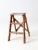 This vintage wooden step ladder features two steps and a rustic finish with old white paint splatters that add aged...