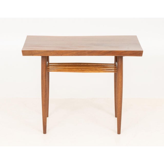 George Nakashima (American, 1905-1990) American Black Walnut End Table, 1964-5, with live edge and spindle shelf on four...