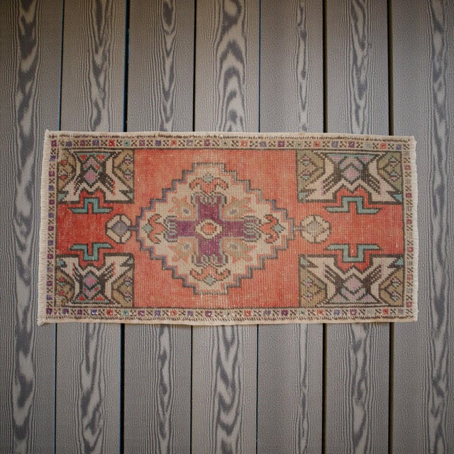 This vintage Oushak mat radiates a warm, sun-faded charm with its earthy terracotta field and traditional Anatolian...