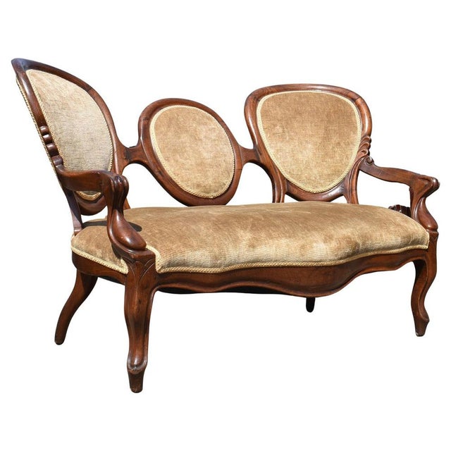 A beautifully shaped Victorian rosewood sofa featuring a distinctive triple oval backrest, elegant scroll arms and...