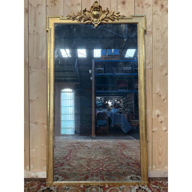 Louis XVI style mirror with a pediment, dating from the Napoleon III era, with a giltwood frame. The frame is adorned with...