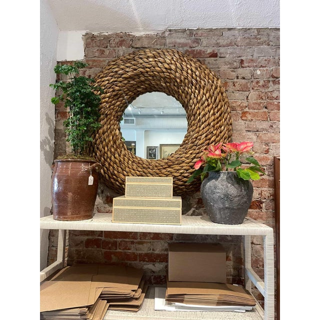 Large statement mirror featuring a thick frame crafted from handwoven water hyacinth, creating a bold circular form with...