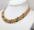 Circa 1991 goldtone offset oval domed in lines of 3 with oval faux-amethyst, emerald, citrine & sapphires articulated...