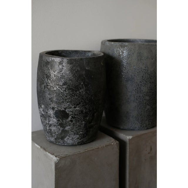 Crucibles — originally used for melting metals at high temperatures. Their dark, mineral surface is a direct result of use...