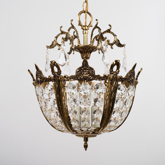 A small 3-Light crystal glass chandelier, Spain circa 1950s. It has cut glass droplets arranged in a basket from a brass...