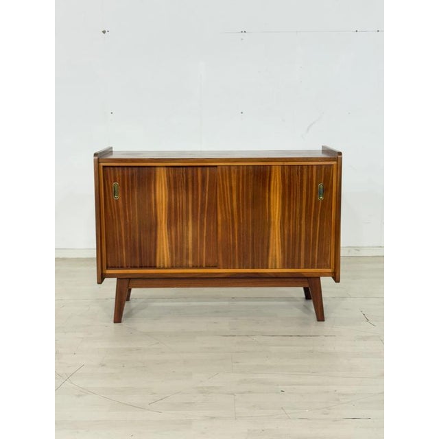 Beautiful, compact vintage chest of drawers in a timeless mid-century design. The piece impresses with its expressive,...