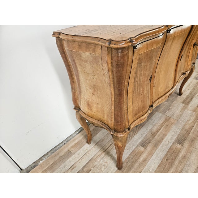 An elegant walnut sideboard crafted in the Baroque style, characterized by sinuous lines and excellent construction...