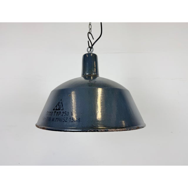 This industrial lamp was made by emax in hungary during the 1960s. It features a dark blue enamel shade with white enamel...