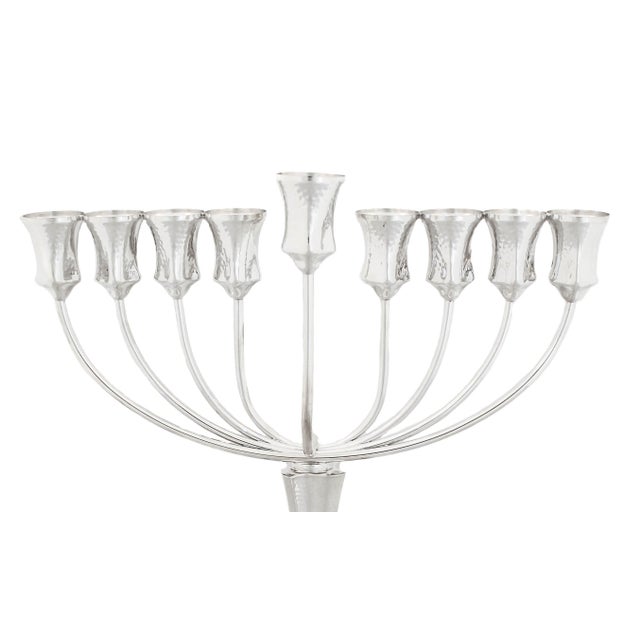Being offered is a new sterling silver menorah made in Israel. It has a hammered finish with a swirl base and square shape...