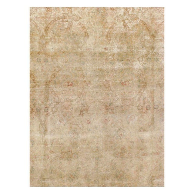 This early 20th-century Persian Tabriz room-size carpet presents a softly rendered allover floral design across a warm...
