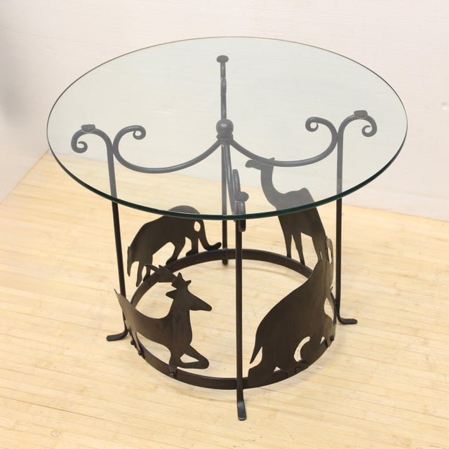 Vintage round accent table with iron loops holding the glass top and 4 animals on a metal ring below, forming a carousel...