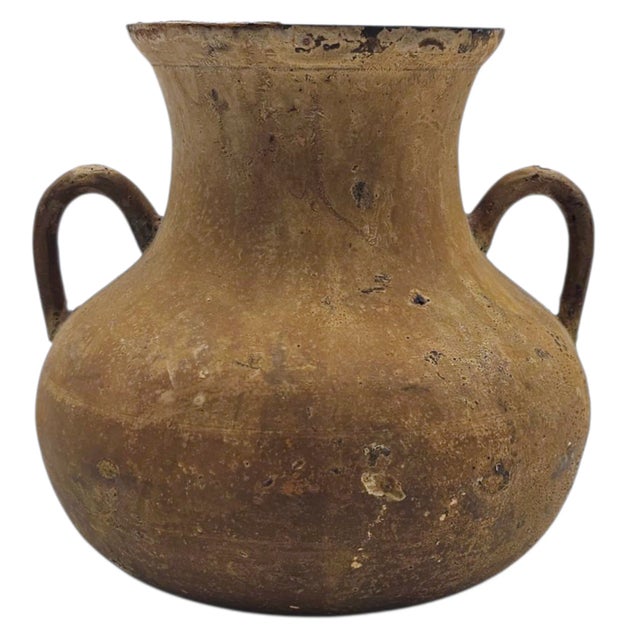 This set of three patinated metal vases offers a striking study in timeworn texture and primitive form. Each vessel...