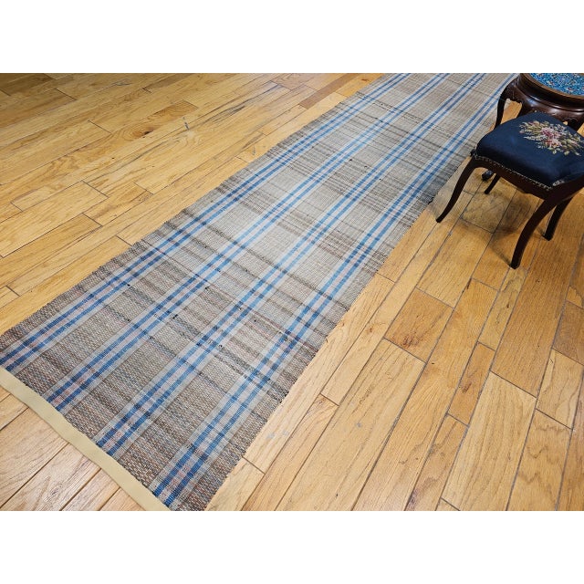A beautifully preserved vintage hand-woven Amish American rag runner dating back to the early 1900s. Featuring a...