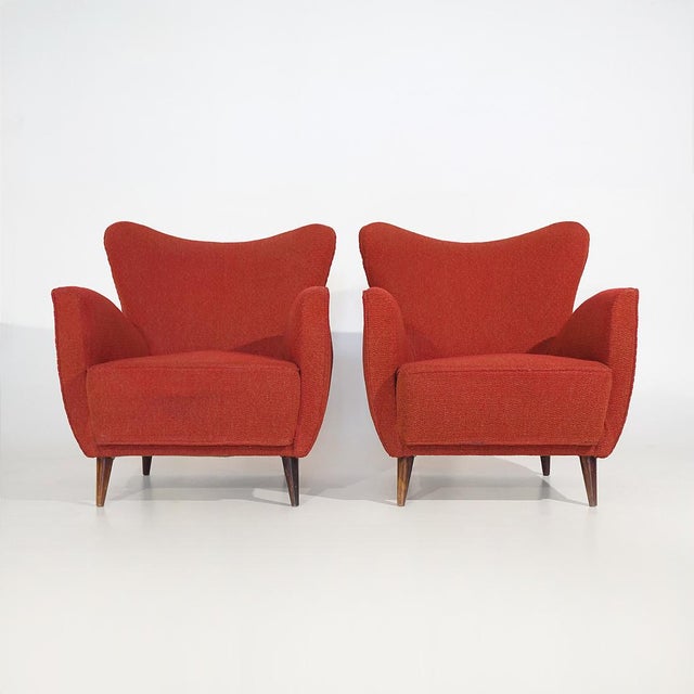 Pair of Italian armchairs produced in the 1950s, distinguished by their soft, enveloping silhouette that reflects the...