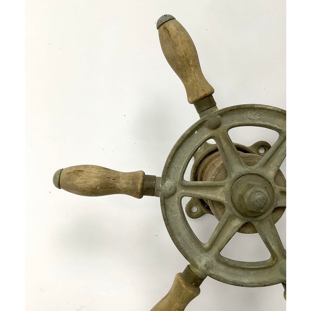 Circa 1940s cast iron Wilcox Crittenden boat steering wheel stamped with "WC", has wood handles. Steering wheel has...