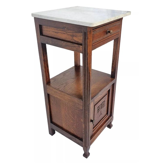 Add a touch of classic French sophistication to your home with this stunning antique 1920s French oak nightstand....