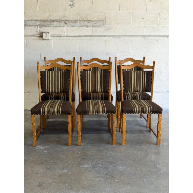 This set of 6 dining chairs showcases carved wooden frames and high backrests. Vintage 1970s. Crafted from solid oak In...