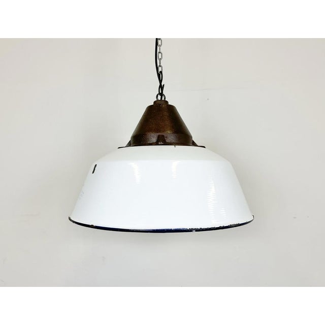 Industrial hanging lamp manufactured by Szarvasi Vas - Fém in Hungary during the 1960s. It features a white enamel shade,...