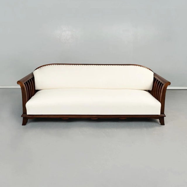 Italian modern Wooden sofa with white fabric, 1940s A sofa with wooden structure. The sofa has a rectangular seat and a...