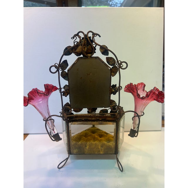 The casket features beveled glass panels, an ormolu (gilt brass) frame, a top mirror surrounded by decorative metal leaves...