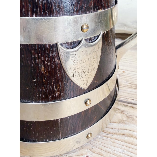 A beautiful antique circa 1888 oak cup with applied metal rims, frame, and shield, engraved to read: R. M. A. Sports 1888...