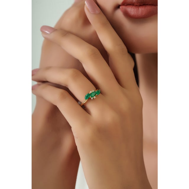 This cluster ring features 1 carat of marquise-cut emeralds set in 14K yellow gold. The emerald measuring 3 x 5.5 mm,...