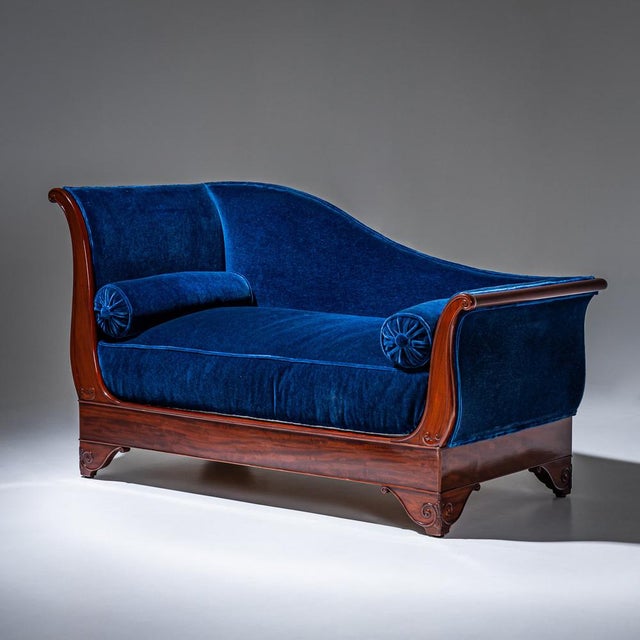 Mahogany méridienne with a left-facing orientation, featuring subtle volute decoration on the legs and sled-shaped sides....