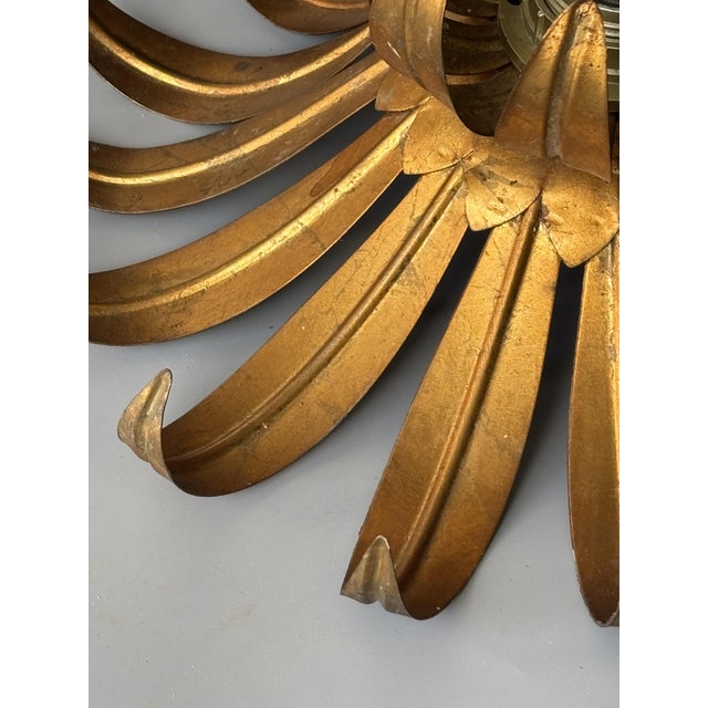 A stunning pair of vintage wall sconces in gilt metal, featuring a particularly sculptural floral silhouette, in the style...