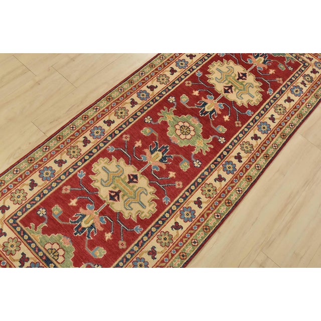A traditional tribal Caucasian Kazak runner hand-knotted with fine wool on a cotton foundation. This rug features...