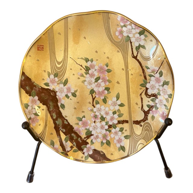 Beautiful coordinating set of four floral glass plates featuring Japanese-inspired botanical designs against warm gold-...