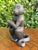 Vintage cast metal monkey sculpture holding an orb with its tail wrapped around the base. Finished in a dark patina with...