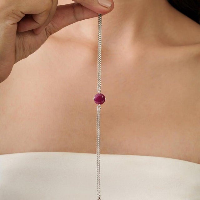 A refined 925 sterling silver bracelet featuring a single natural ruby in a classic round cut (10 mm, 4.9 carats). The...