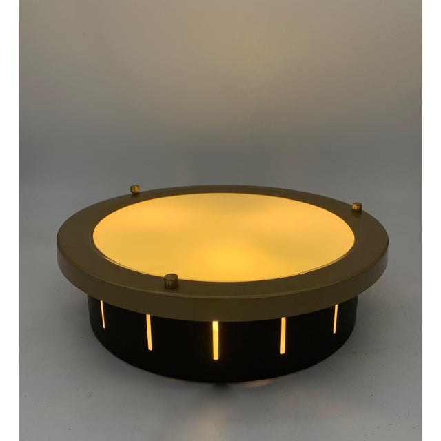 Circular ceiling lamp or ceiling light, featuring a metal frame with a brass/gold finish and a large central diffuser in...