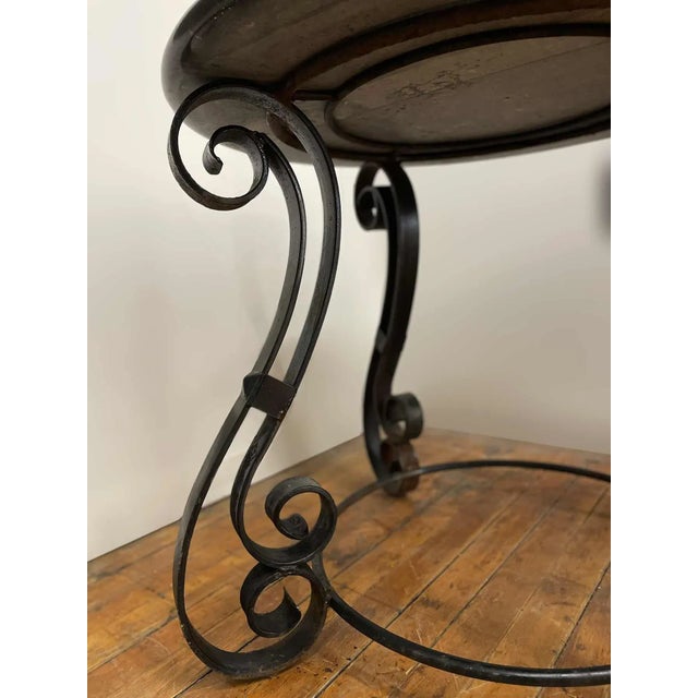 Antique wrought iron center table with round black marble top. Marble top is removable for shipping.