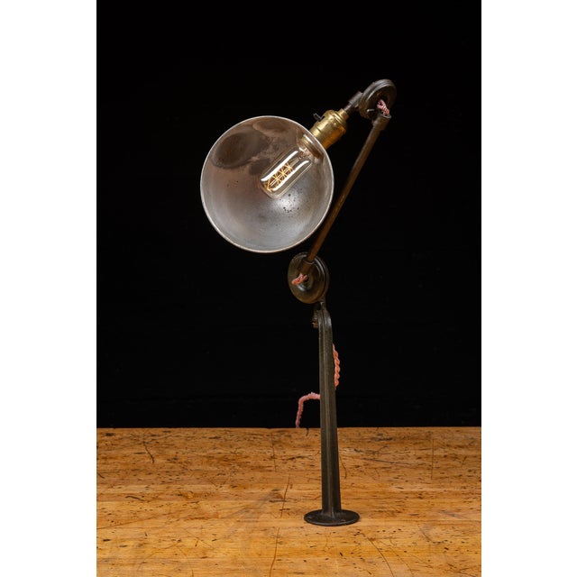 Industrial articulating task lamp designed for permanent mounting to the edge or surface of a workbench, drafting table,...