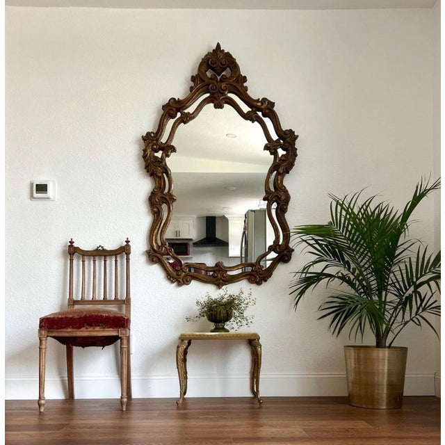 An eye-catching and very large Baroque / Hollywood Regency / Neoclassical Style “Statement Mirror” featuring a golden...