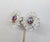 1960s goldtone prong set red/pink/blue aurora borealis center rhinestone with clear beaded surround clip earrings. Marked...