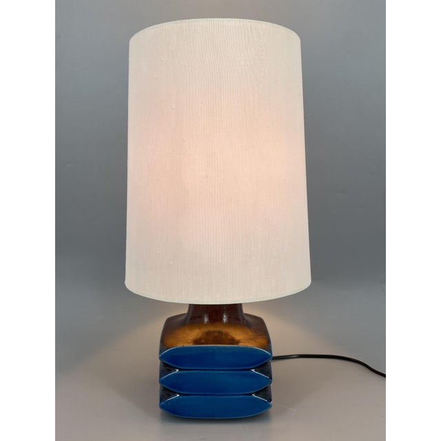 A table lamp * designed by cari zalloni for leola * made of ceramic * glazed in intense blue and aubergine * ​​cable with...