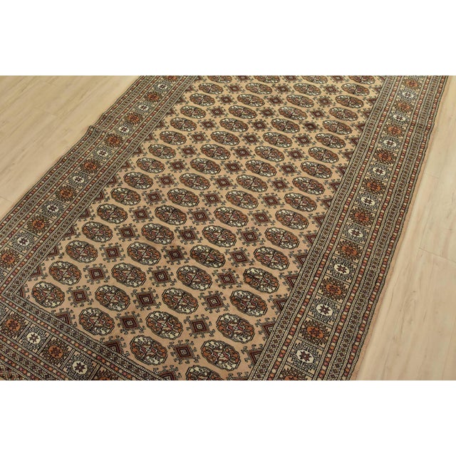 A tribal Bokhara rug hand-knotted with fine wool on a cotton foundation. This rug features rows of repeating medallions...