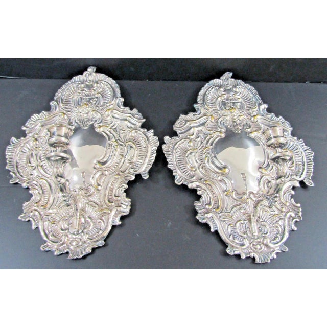 This is a matched pair of Baroque-style repousse silver plated brass candle sconces, made by Blaker in Germany before...